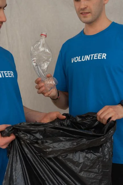 who-we-are Close-up of gloved hands cleaning a remote control with a cloth and spray bottle to disinfect it.